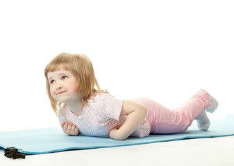 Obraz na płótnie Canvas Baby girl exercising lying on a training mat
