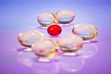 Pills (capsules) of cod-liver oil on violet, macro view with sel