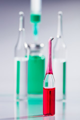 Red ampula and syringe macro still life on white