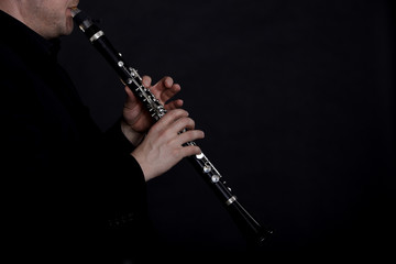 Clarinet player in front of black background