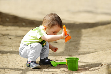 little child playing in sandbox