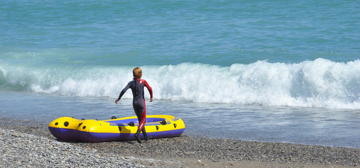 enfant jouant à la plage avec bateau gonflable