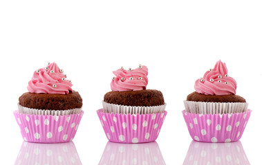 Three Chocolate cupcakes with pink butter icing