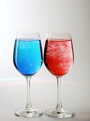 Two wine glasses  and spreading red and blue ink