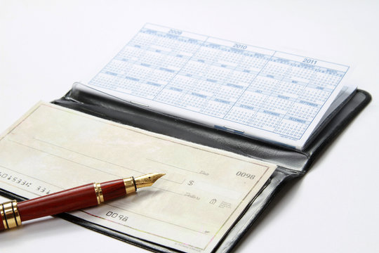 An open checkbook and a ballpen isolated on white