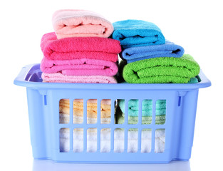 Plastic basket with bright towels isolated on white
