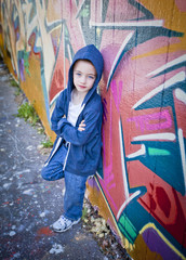 Young boy against graffiti wall