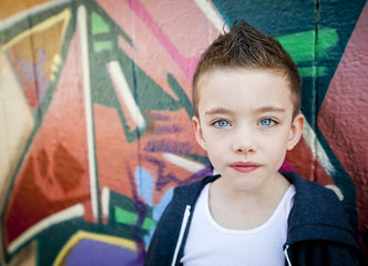 Young boy against graffiti wall