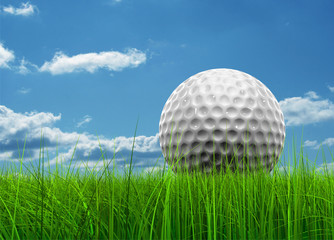 Conceptual golf ball in grass over a blue sky