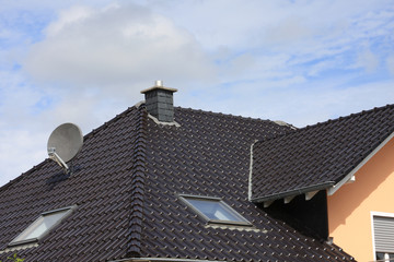 schwarzes Hausdach mit Satelittenanlage