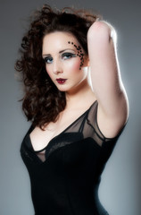 Fototapeta premium Pretty young female in black with beautiful make up