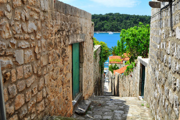 Fototapeta premium A traditional old picturesque street in Cavtat Croatia leading down to the beautiful blue sea below 