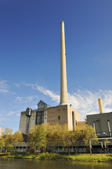 Fototapeta premium Tall chimney of powerhouse on the river Saar in Saarbrücken