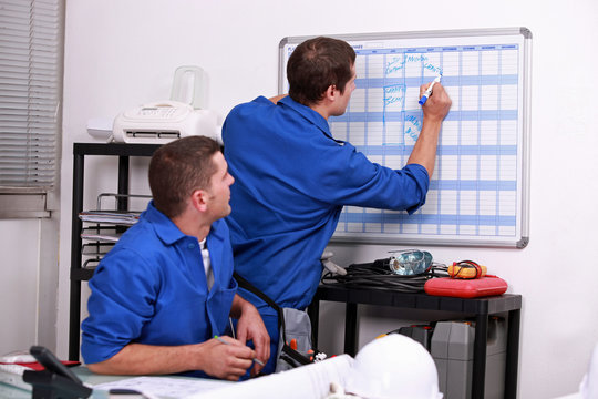 Manual workers writing on a calendar