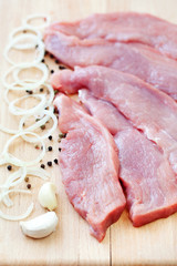 raw pork steaks on a cutting board with spices