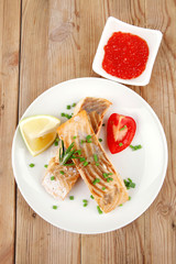 salmon fillet on white dish with red caviar