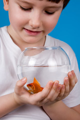 Boy holds a fishbowl with a goldfish
