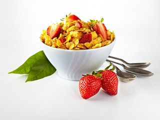 bowl of cornflakes and strawberries on white background