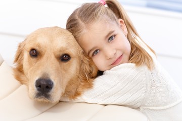 Cute little girl and dog embracing