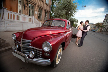 Pretty couple near the vintage car