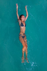 beautiful young woman floating in a basin