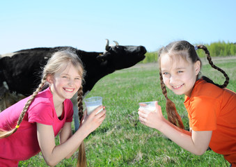 Two little girls drinking milk