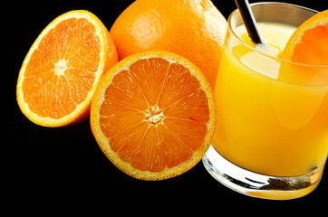 Orange juice and slices of orange on the black