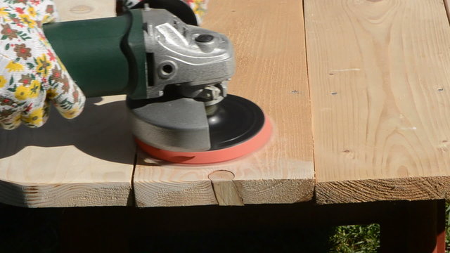 grinder tool grinding wooden table in the garden