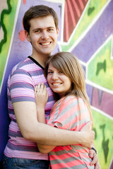 Young couple near graffiti background.