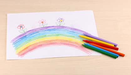 Obraz premium Children's drawing of rainbow and pencils on wooden background