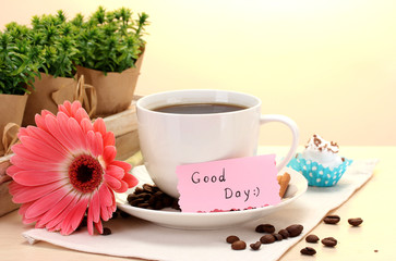 cup of coffee and gerbera beans, cinnamon sticks on wooden table