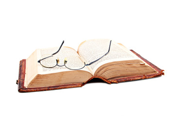 Old open bible with reading glases