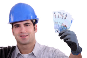Construction worker holding up money