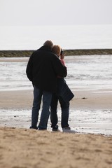 verliebtes Pärchen schaut auf Meer,Frau fotografiert