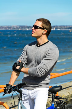 Portrait of handsome male with bicycle by the sea