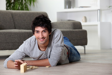 Man playing with dominoes at home