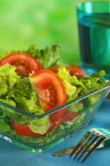 Fresh salad of lettuce and tomato with a glass of water