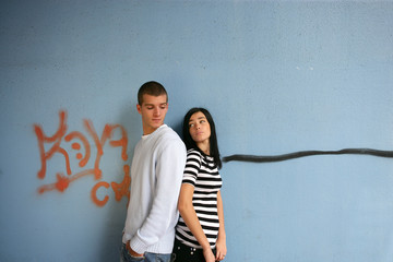Obraz na płótnie Canvas Młoda para stała przy ścianie graffiti, pokrytej