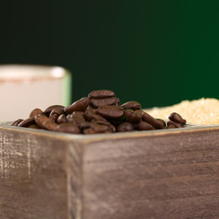 Roasted coffee beans and brown sugar in wooden container