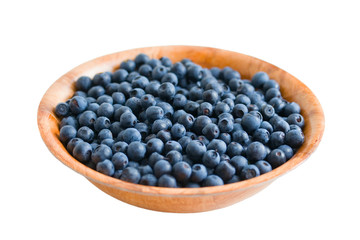 blueberry in round wooden plate. Isolated on white.