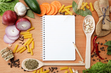 notebook for recipes and spices on wooden table