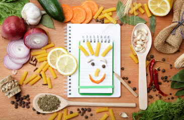 notebook for recipes and spices on wooden table