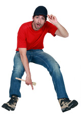 A male painter pointing at the floor.