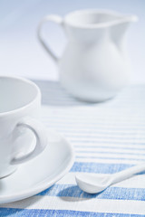 composition of white cup and spoon and jug