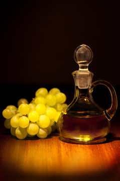 Eine Flasche Traubenkernöl und daneben Weintrauben