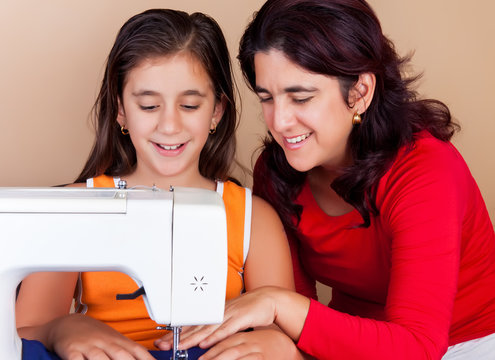 Mother and daughter sewing together