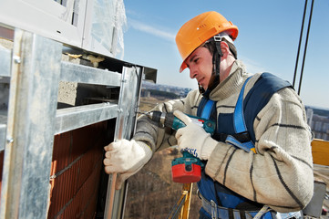 Worker builders at facade tile installation