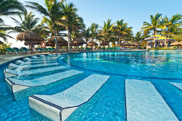 Tropical swimming pool with sunbeds in Mexico
