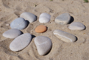Obraz premium red stone surrounded by grey stones