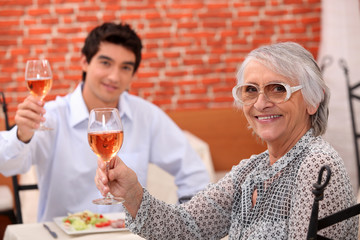 Grandmother and grandson  having meal in restaurant